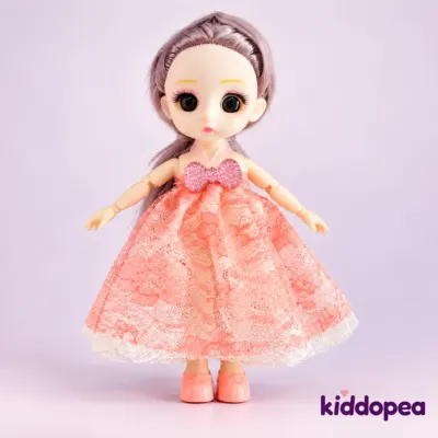 A doll in a peach lace dress standing on her own.